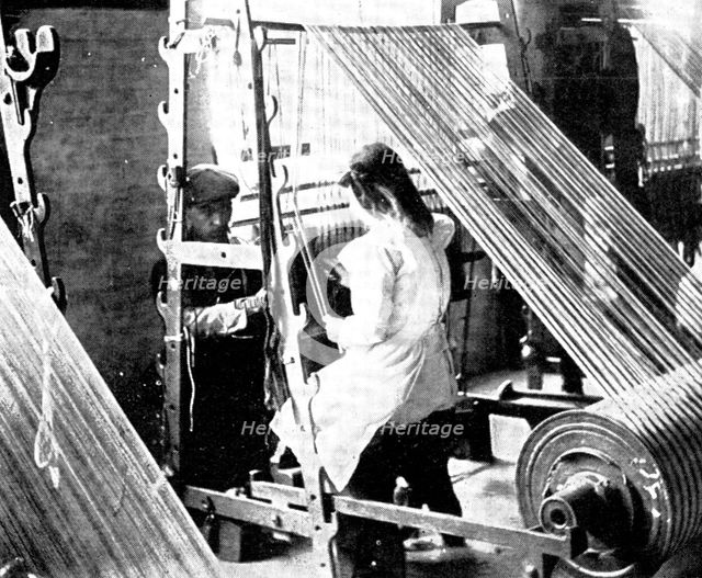 Preparing for the weaving: drawing-in, 1909.  Creator: Unknown.