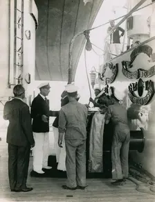 Preparing to hoist a case from the deck of H.M.S. Suffolk at Portsmouth, July 1935. Creator: Topical Press Agency