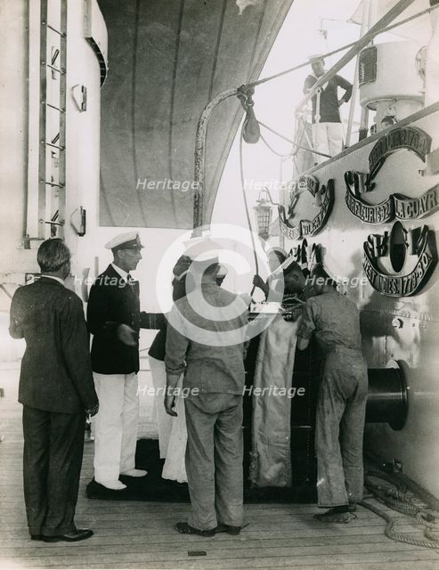 Preparing to hoist a case from the deck of  H.M.S. Suffolk at Portsmouth, July 1935. Creator: Topical Press Agency.