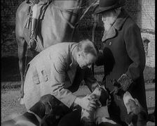Prime Minister Stanley Baldwin Petting Dogs. Beside Him a Male Civilian Stands Next to a Horse, 1924 Creator: British Pathe Ltd