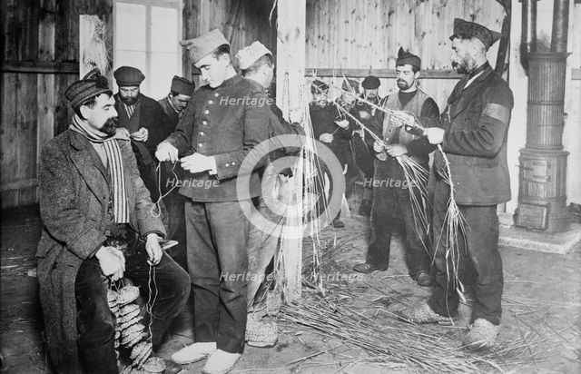 Prisoners at Zossen making straw shoes, 24 Feb 1915. Creator: Bain News Service.