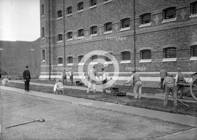 Prisoners cutting grass at Wormwood Scrubs prison, London, c1900-1950. Artist: Unknown