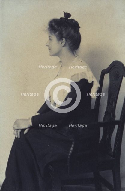 Profile portrait of a woman seated in chair, facing left with hands on her knees, c1900. Creator: Misses Selby.