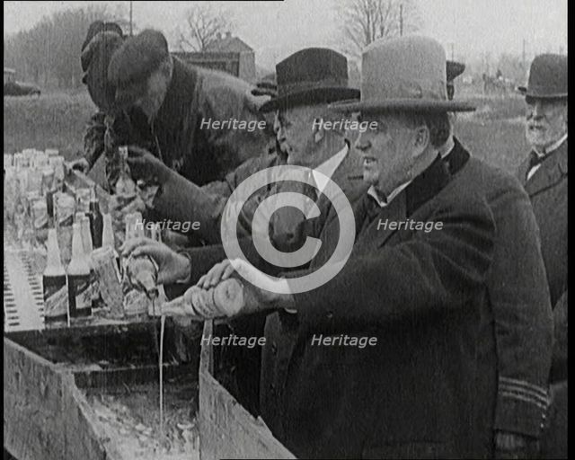Prohibition Scenes in the United States of America. Men Pouring Away Bottles of Beer Into..., 1920. Creator: British Pathe Ltd.