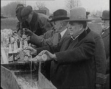 Prohibition Scenes in the United States of America. Men Pouring Away Bottles of Beer Into..., 1920. Creator: British Pathe Ltd