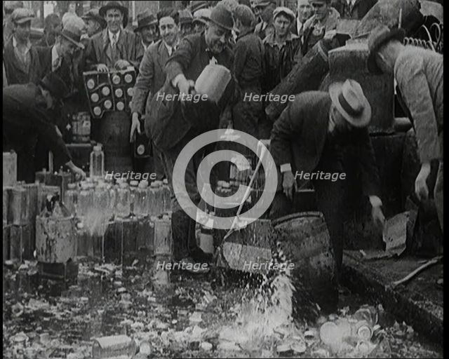 Prohibition Scenes in the United States of America. Men Smashing Bottles of Alcoholic..., 1920. Creator: British Pathe Ltd.