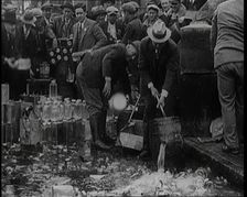Prohibition Scenes in the United States of America. Men Smashing Bottles of Alcoholic..., 1920. Creator: British Pathe Ltd