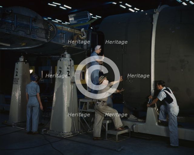 Putting the nose section of a mighty transport...Consolidated Aircraft..., Fort Worth, Texas, 1942. Creator: Howard Hollem.
