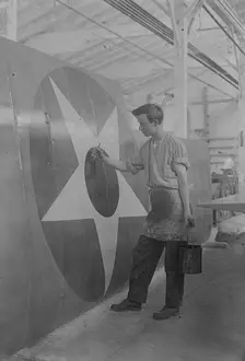 Putting U.S. Emblem on plane, between c1915 and c1920. Creator: Bain News Service