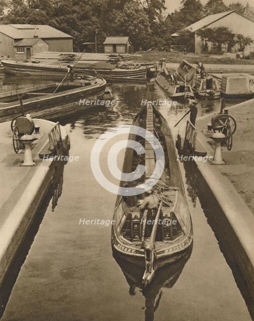'Pushing a Monkey Boat Through The Lock at Brentford', c1935. Creator: Unknown.