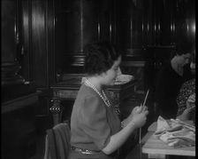 Queen Elizabeth Knitting at a Large Sewing Group Hosted in Buckingham Palace, 1940. Creator: British Pathe Ltd