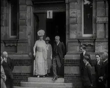 Queen Mary Accompanied by a Group of Officials Emerging from a Building , 1924. Creator: British Pathe Ltd