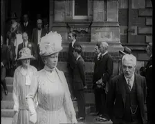 Queen Mary and King George V Accompanied by a Group of Officials Emerging from a Building , 1924. Creator: British Pathe Ltd