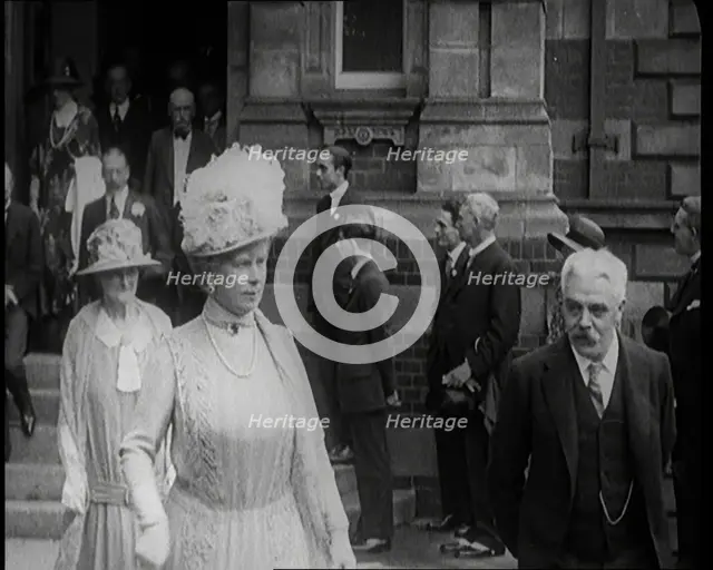 Queen Mary and King George V Accompanied by a Group of Officials Emerging from a Building , 1924. Creator: British Pathe Ltd.
