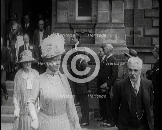 Queen Mary and King George V Accompanied by a Group of Officials Emerging from a Building , 1924. Creator: British Pathe Ltd.
