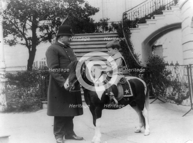 Quentin Roosevelt on pony beside White House policeman, 1905. Creator: Frances Benjamin Johnston.