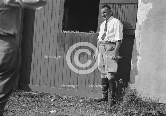 Rothbart, Albert, Mr., grounds, with unidentified man standing by a stable door, c1920-1935. Creator: Arnold Genthe.