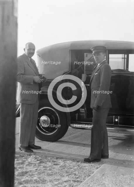 Rothbart, Albert, Mr., standing by his car with his chauffeur, between 1920 and 1935. Creator: Arnold Genthe.