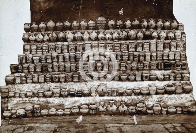 Rows of decorated pharmacy jars and other objects, c19th century. Creator: Unknown.