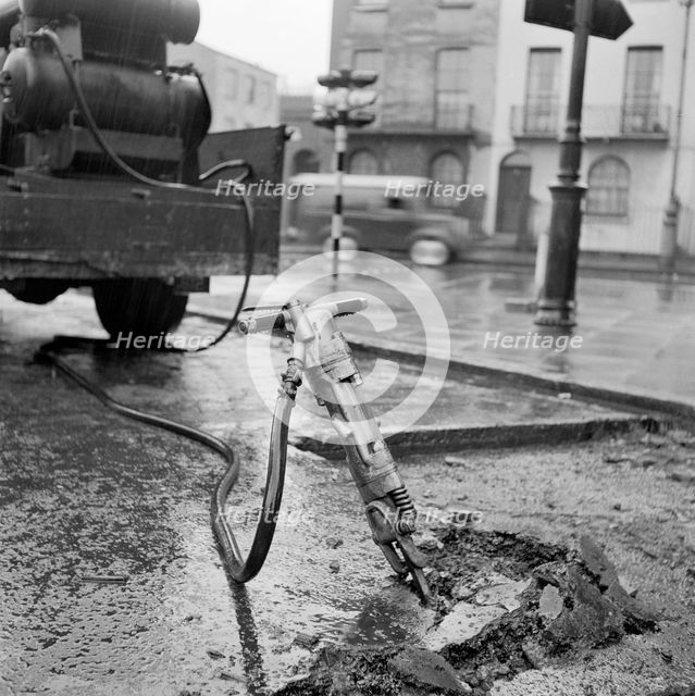 Road works with pneumatic drill, London, 1960-1965. Artist: John Gay