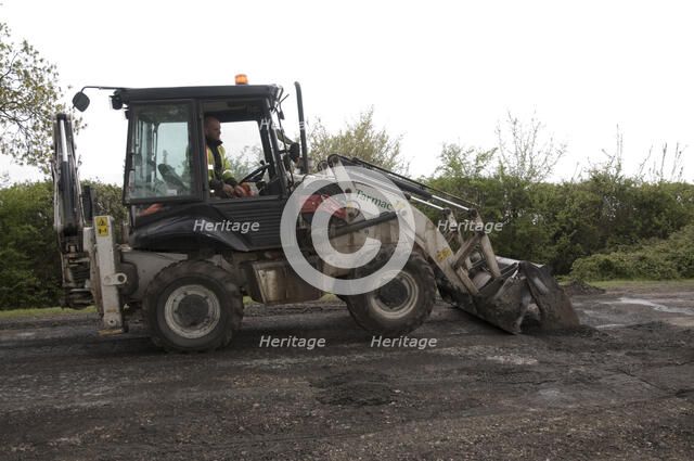 Road resurfacing work repairing potholes Artist: Unknown.