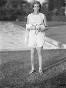 Rossbach, Miss, holding puppies, standing outdoors, 1932 June 30. Creator: Arnold Genthe