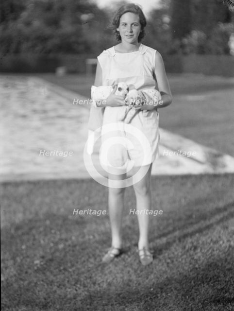 Rossbach, Miss, holding puppies, standing outdoors, 1932 June 30. Creator: Arnold Genthe.
