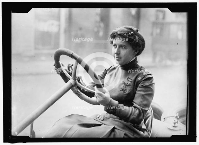Race car driver Joan Newton Cuneo, seated in racing car, facing left, between 1910 and 1917. Creator: Harris & Ewing.