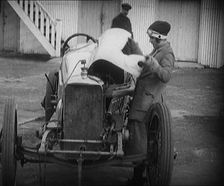 Racing Driver Ivy Cummins Wearing a Racing Outfit Opening a Bonnet of Her Car, 1920. Creator: British Pathe Ltd