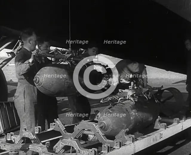 RAF Ground Crew Members Fixing Bombs to an Avro Lancaster Bomber, 1942. Creator: British Pathe Ltd.