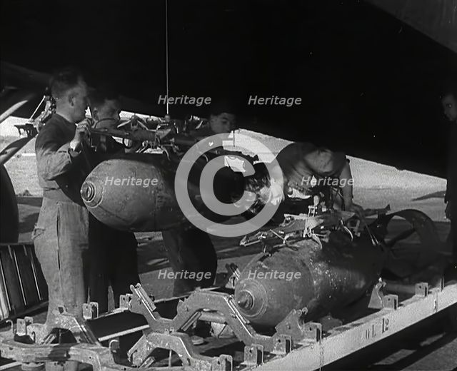 RAF Ground Crew Members Fixing Bombs to an Avro Lancaster Bomber, 1942. Creator: British Pathe Ltd.