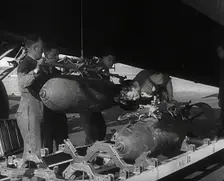 RAF Ground Crew Members Fixing Bombs to an Avro Lancaster Bomber, 1942. Creator: British Pathe Ltd