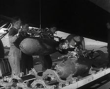 RAF Ground Crew Members Fixing Bombs to an Avro Lancaster Bomber, 1942. Creator: British Pathe Ltd