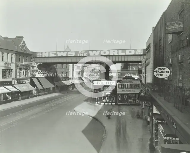 Railway bridge and advertising over the Brixton Road, Lambeth, London, 1938. Artist: Unknown.