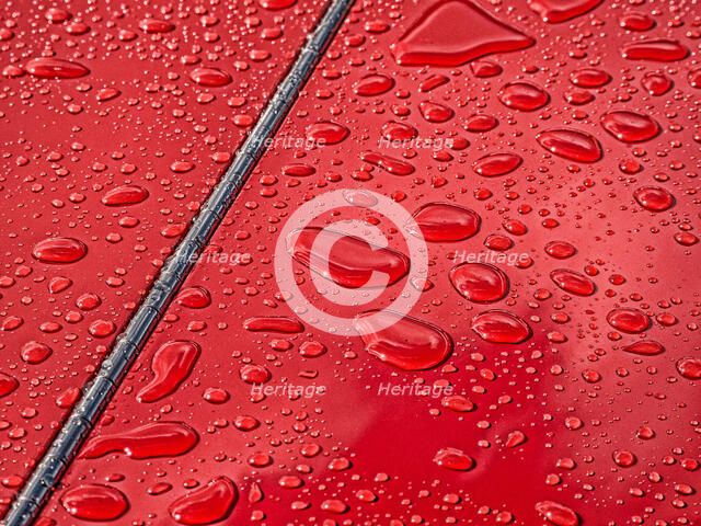 Raindrops beading on classic car paintwork
