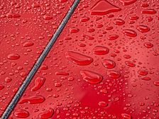 Raindrops beading on classic car paintwork