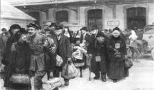 Rapatries; La sortie de la gare: un officier permissionnaire a retrouve ses enfants Creator: J Simont