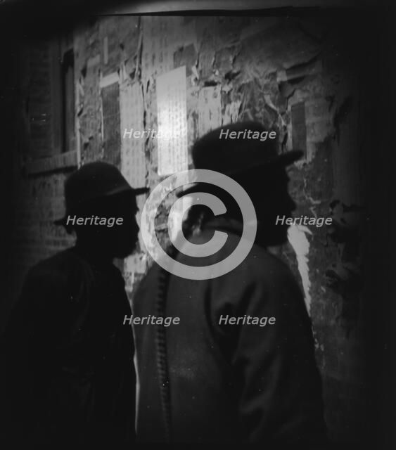 Reading wall notices, Chinatown, San Francisco, between 1896 and 1906. Creator: Arnold Genthe.