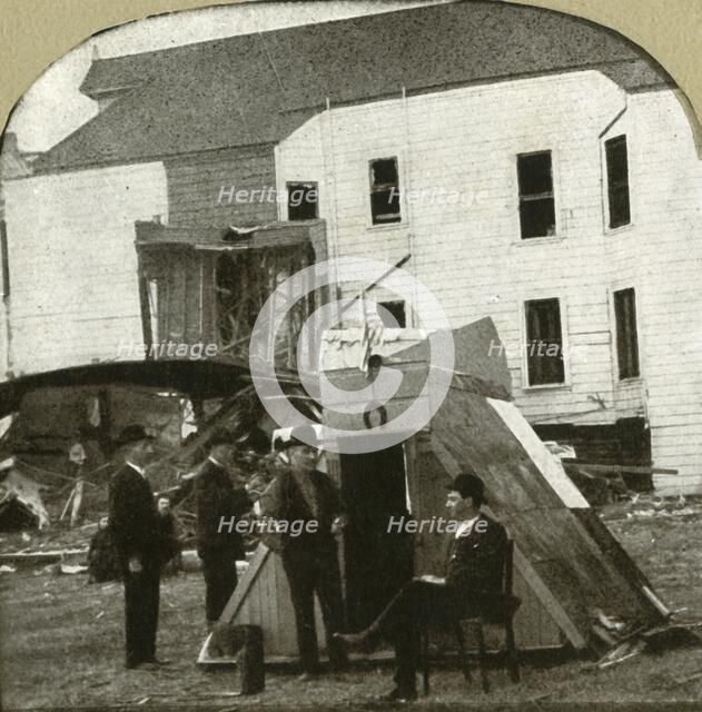 'Refugees' camp, former dwelling in ruins in background. This is earthquake work', 1906.  Creator: Unknown.