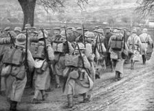 Relief French infantry passing a line of prisoners, Plessis-de-Roye, Picardy, France, 30 March 1918