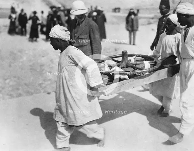 Removing a chariot wheel from the Tomb of Tutankhamun, Valley of the Kings, Egypt, 1922. Creator: Harry Burton.