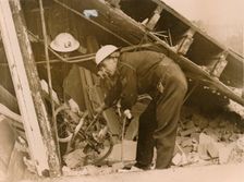 Rescue workers reteieving a bicycle from a wrecked Warden's Post, London. Creator: Unknown