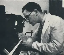 Research worker with microscope (testing the structure of an aluminium alloy) 1941. Artist: Cecil Beaton