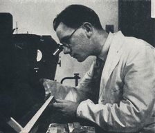 Research worker with microscope (testing the structure of an aluminium alloy) 1941. Artist: Cecil Beaton