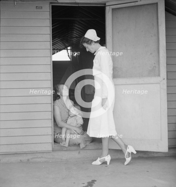 Resident nurse come to visit family, FSA camp, Farmersville, Tulare County, 1939. Creator: Dorothea Lange.