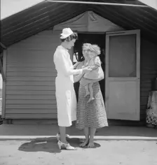 Resident nurse come to visit family, FSA camp, Farmersville, Tulare County, 1939. Creator: Dorothea Lange