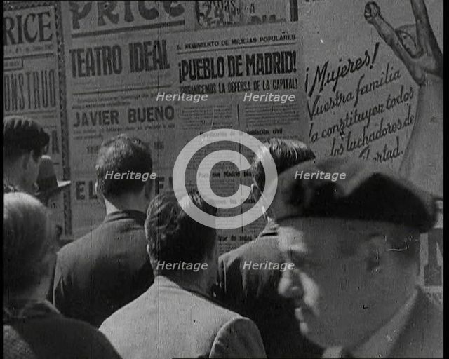 Residents of Madrid Looking at Government Posters on a Wall, 1937. Creator: British Pathe Ltd.