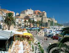 Restaurants in the old port with the Citadel in the background, Calvi, Corsica
