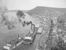 Riverboats distant view of town, between c1900 and 1923. Creator: Unknown
