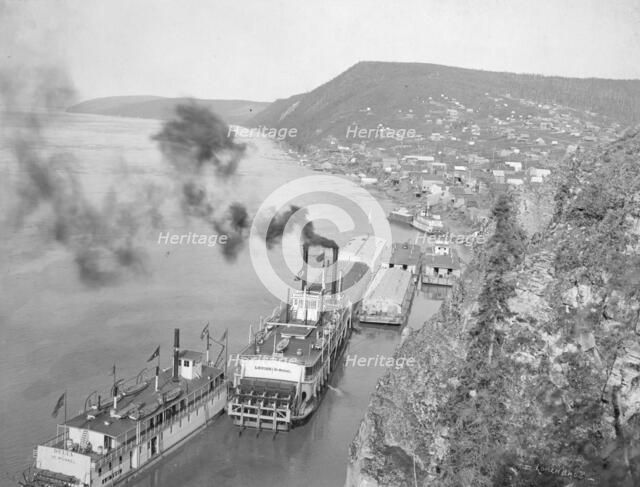 Riverboats distant view of town, between c1900 and 1923. Creator: Unknown.